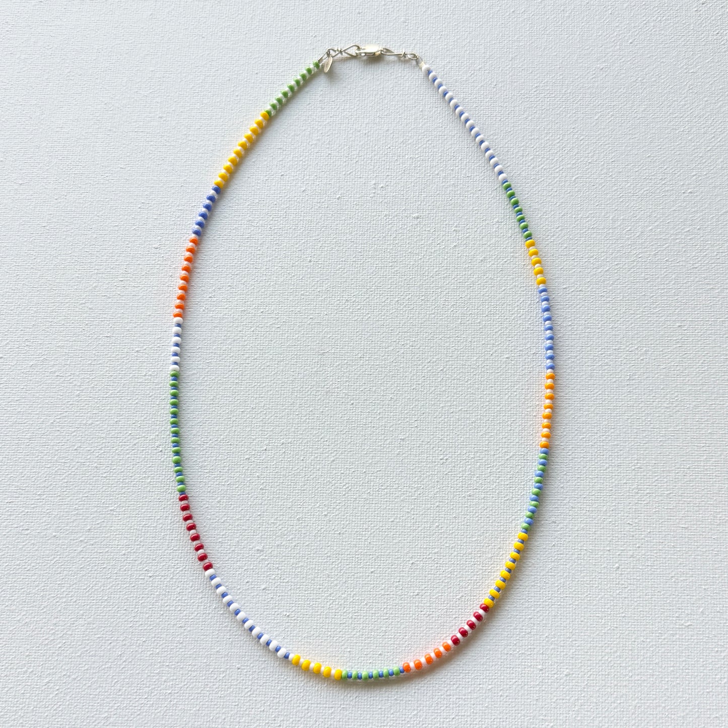 Colorful beaded necklace on a light gray background