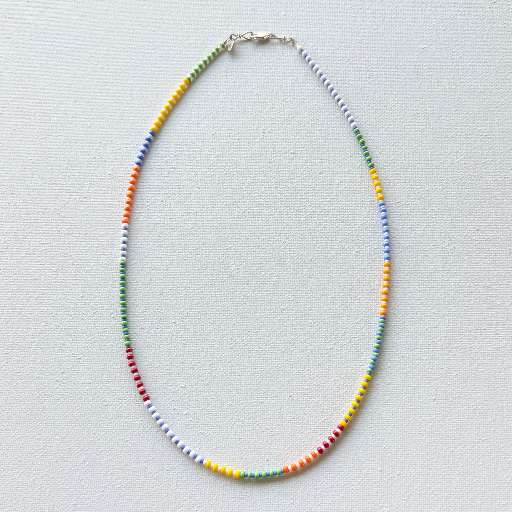 Colorful beaded necklace on a light gray background