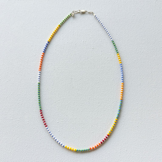 Colorful beaded necklace on a light gray background