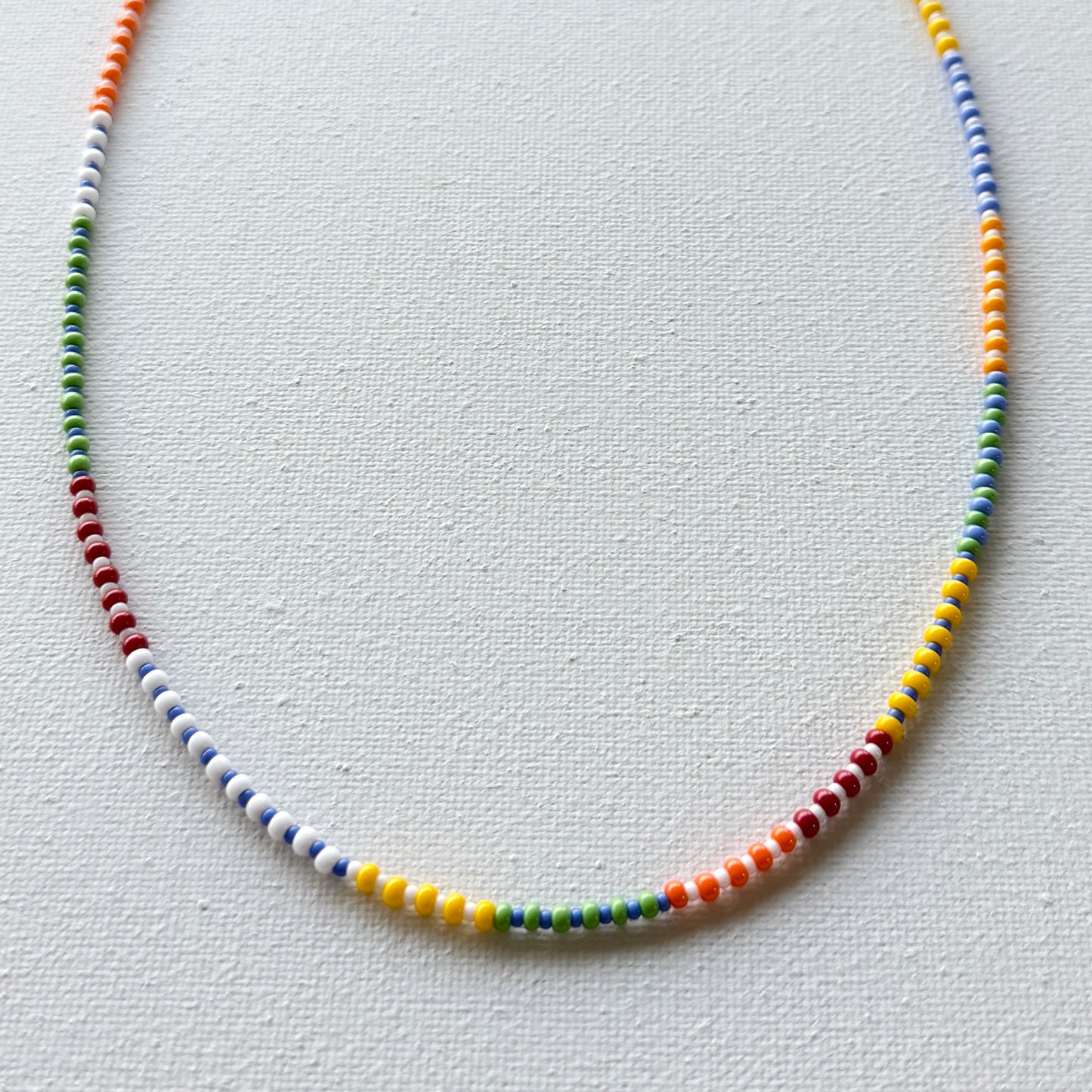 Colorful beaded necklace on a light gray background