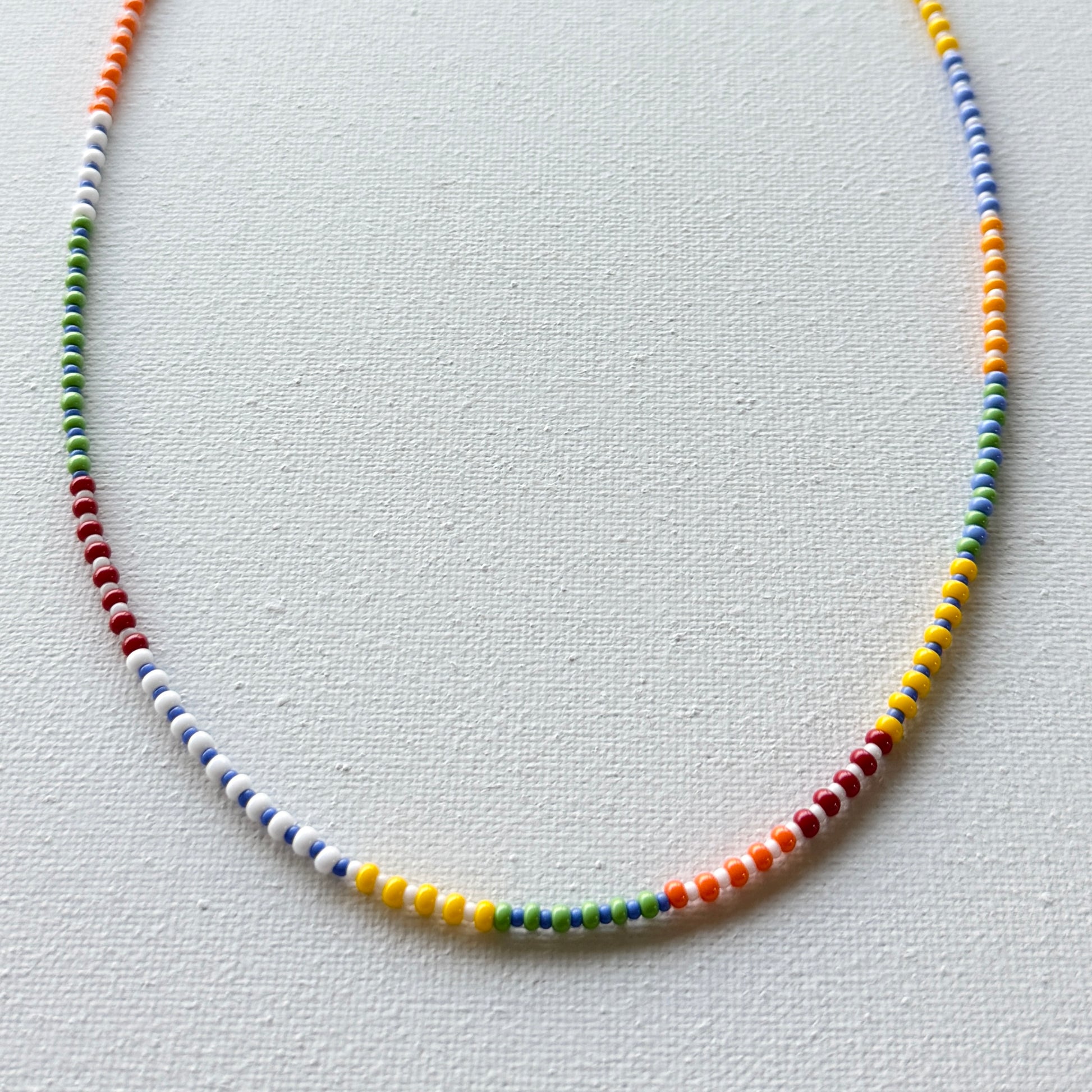 Colorful beaded necklace on a light gray background