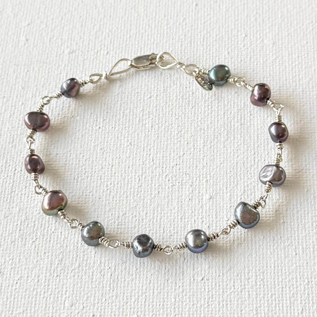 Pearl bracelet with silver chain on a white background
