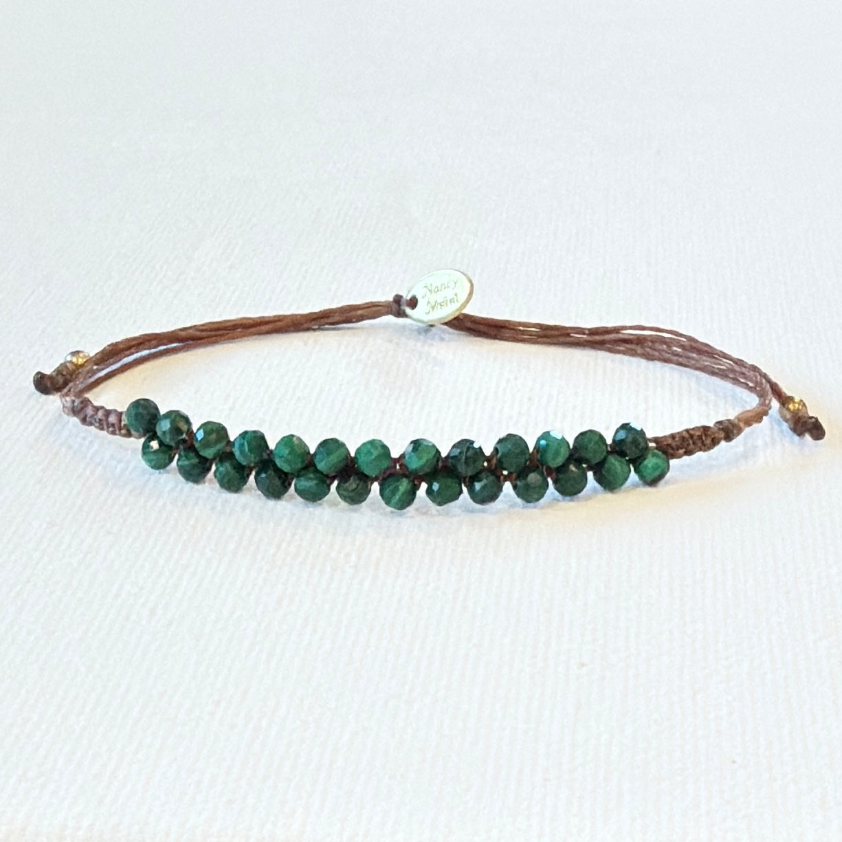 tiny faceted malachite gemstones. Brown waxed nylon and brass.