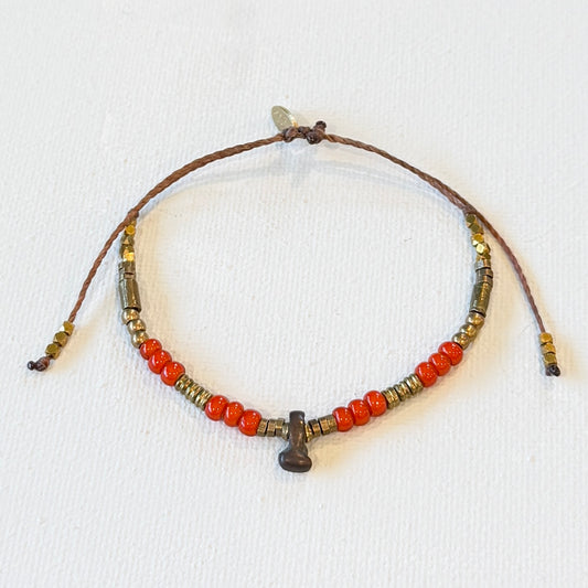 Beaded bracelet with orange and brown beads on a white background. vintage red white heart beads, vintage brass and new brass beads. adjustable in size.