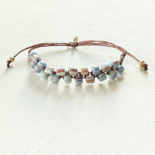 Beaded bracelet with multicolored striped beads on a white background